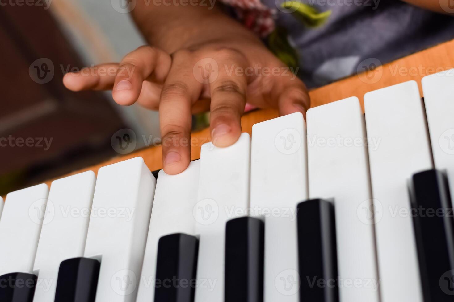 Aziatisch schattig meisje spelen de synthesizer of piano. schattig weinig kind aan het leren hoe naar Speel piano. kind handen Aan de toetsenbord binnen. foto