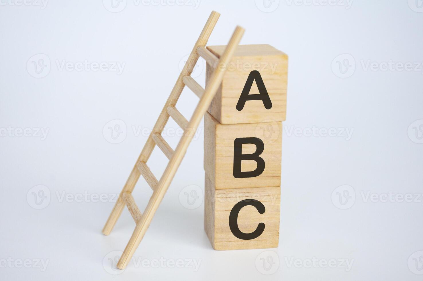 abc tekst Aan houten kubussen met ladder Aan wit achtergrond. aan het leren concept foto