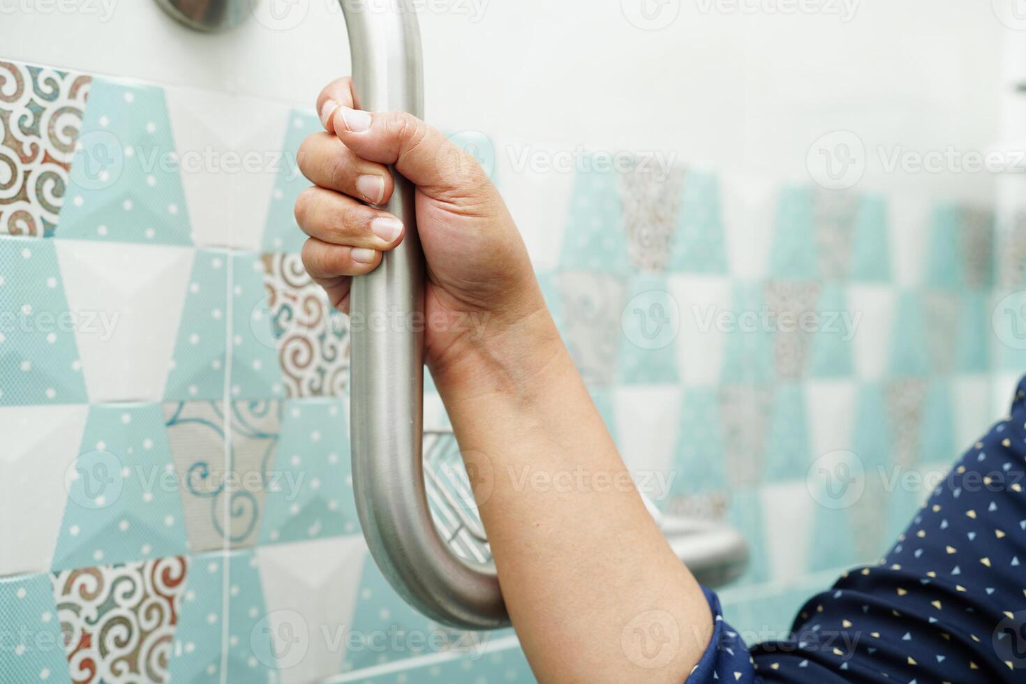 Aziatische vrouw patiënt gebruik toilet steunrail in badkamer, leuning veiligheid handgreep, beveiliging in verpleegziekenhuis. foto