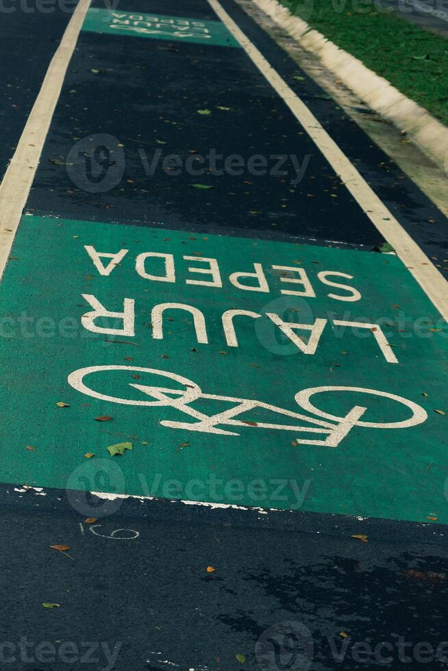 fiets rijbaan teken in geel met solide lijnen Aan asfalt weg in Indonesië foto