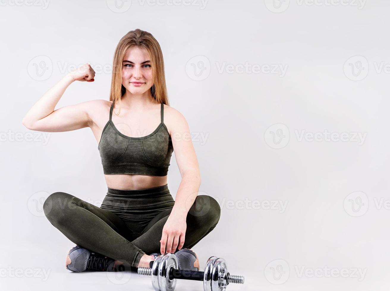 jonge fitte vrouw die haar sterke armen toont geïsoleerd op Gary met kopieerruimte foto