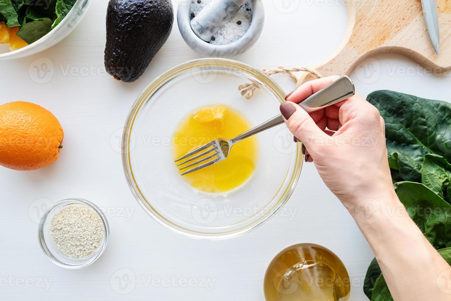 stap voor stap bereiding van spinazie, avocado en sinaasappelsalade. stap 3 - het sinaasappelsap en de olijfolie mengen foto