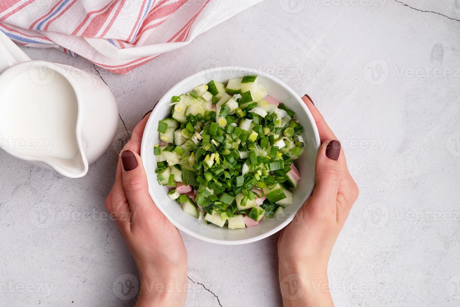 stap voor stap bereiding van koude okroshka-soep met worst, stap 6 - het toevoegen van gehakte groene ui aan het bovenaanzicht van de kom foto