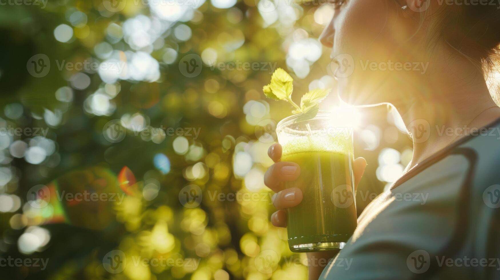 een jogger nemen een breken naar hydrateren met een verfrissend glas van groen sap met zonlicht streaming door de bomen foto