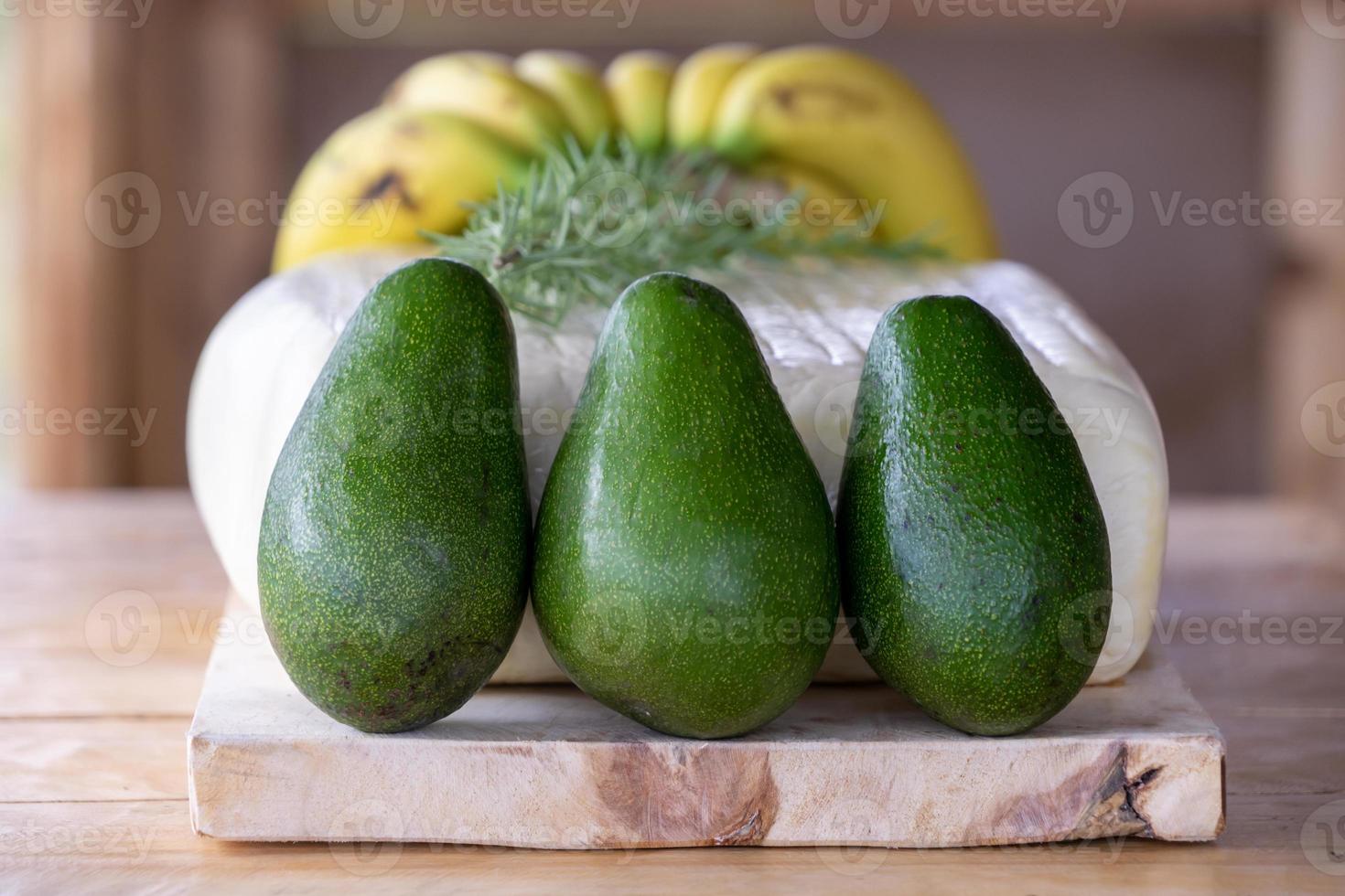 een grote verse kaas met kruiden, bananen en avocado's foto