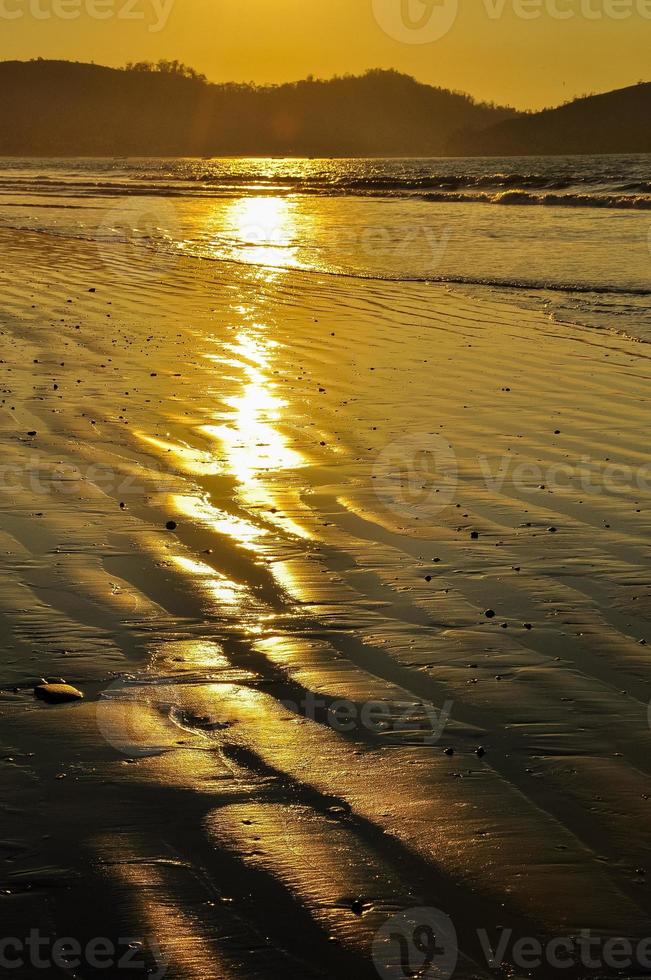 het strand bij zonsondergang foto