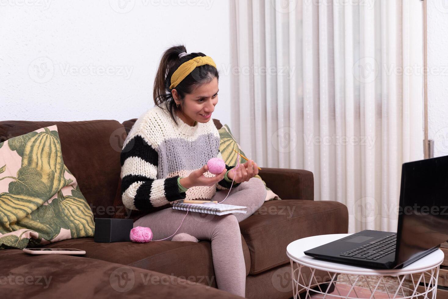 vrouw tonen haar online gemeenschap de materialen ze zullen gebruik voor haar haken werk. foto