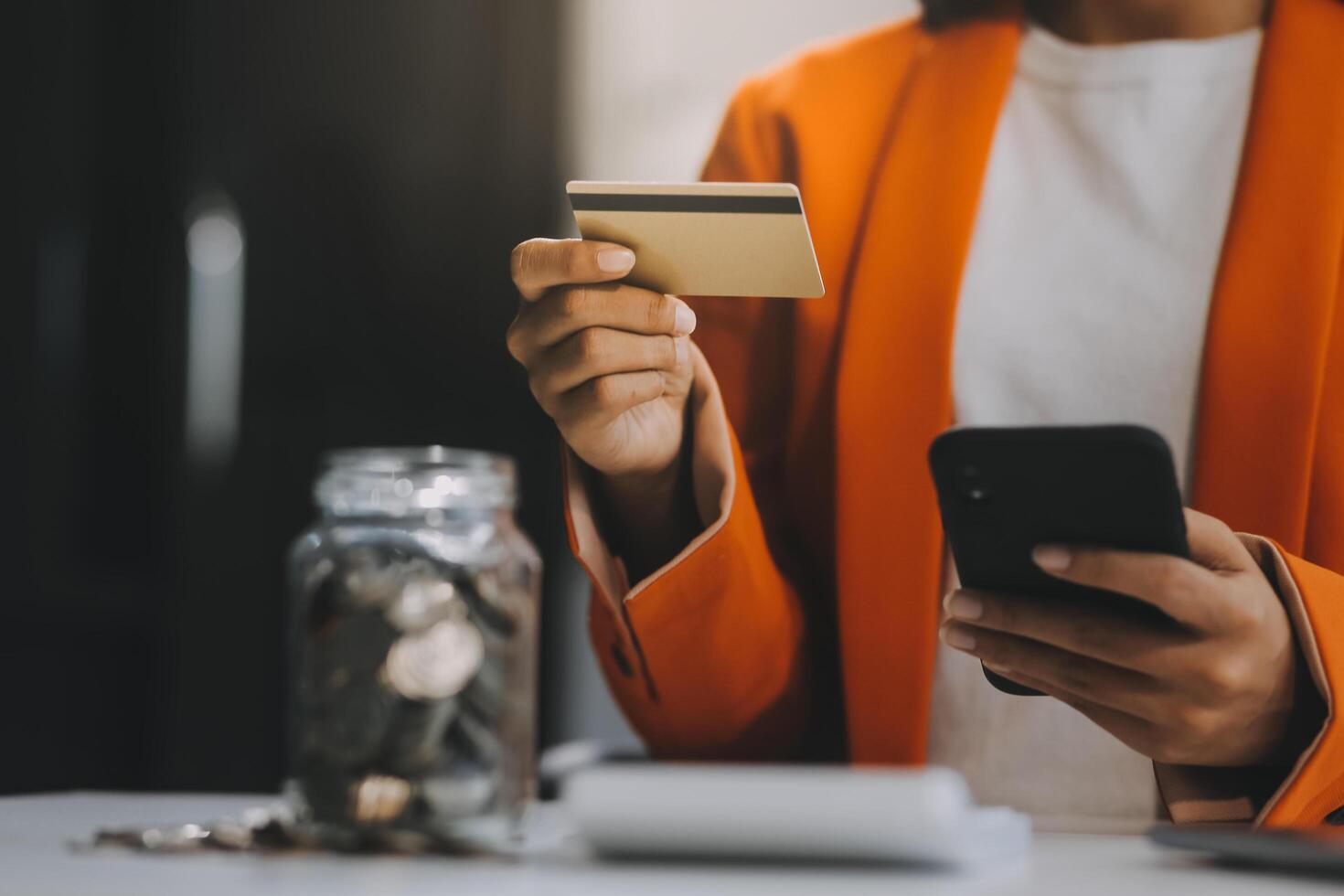 vrouw is aan het doen online aankopen. meisje is aan het doen boodschappen doen gebruik makend van telefoon en credit kaart Bij huis. foto