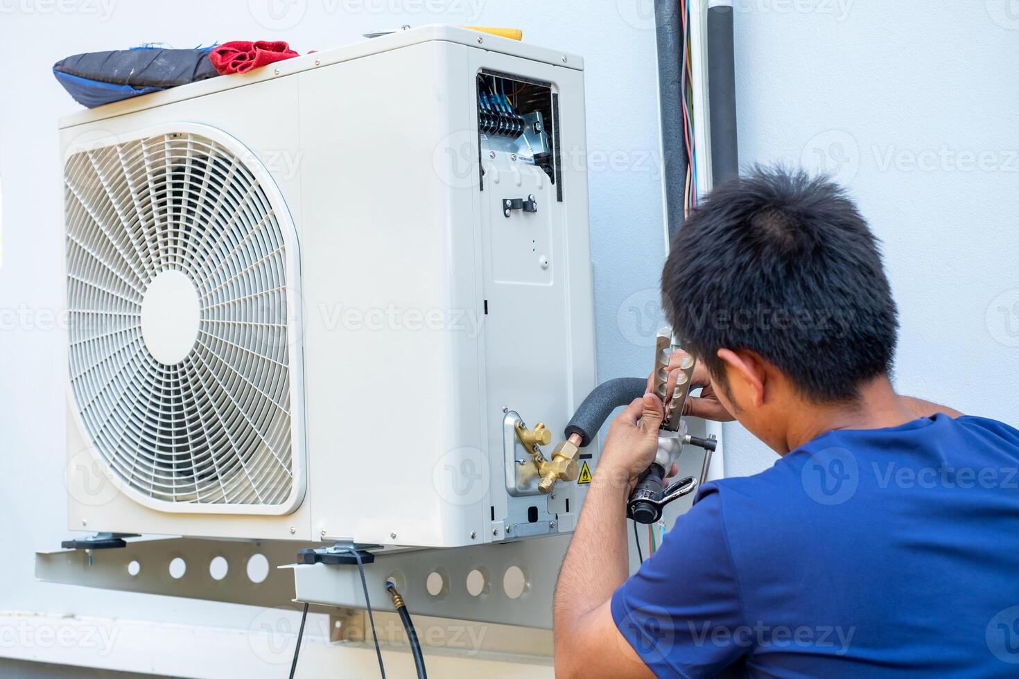 mannetje technicus installeren buitenshuis eenheid van lucht conditioner naar koel de huishouden in de zomer. lucht compressor, elektronisch, heet zomer, hoog temperatuur, tropisch landen foto