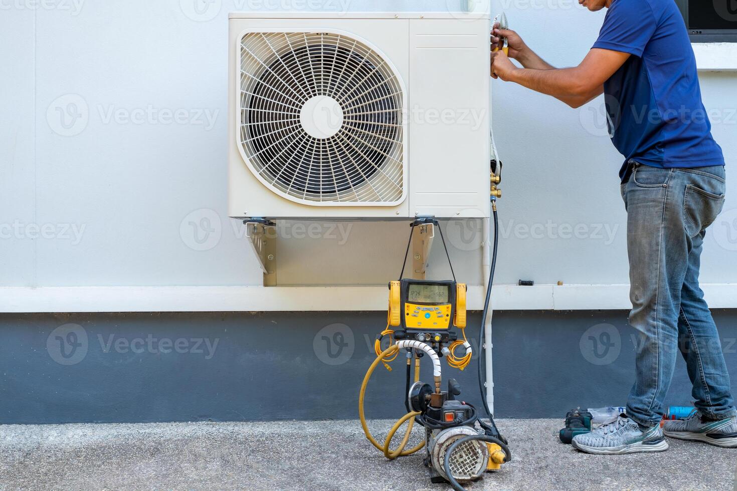 mannetje technicus installeren buitenshuis eenheid van lucht conditioner naar koel de huishouden in de zomer. lucht compressor, elektronisch, heet zomer, hoog temperatuur, tropisch landen foto