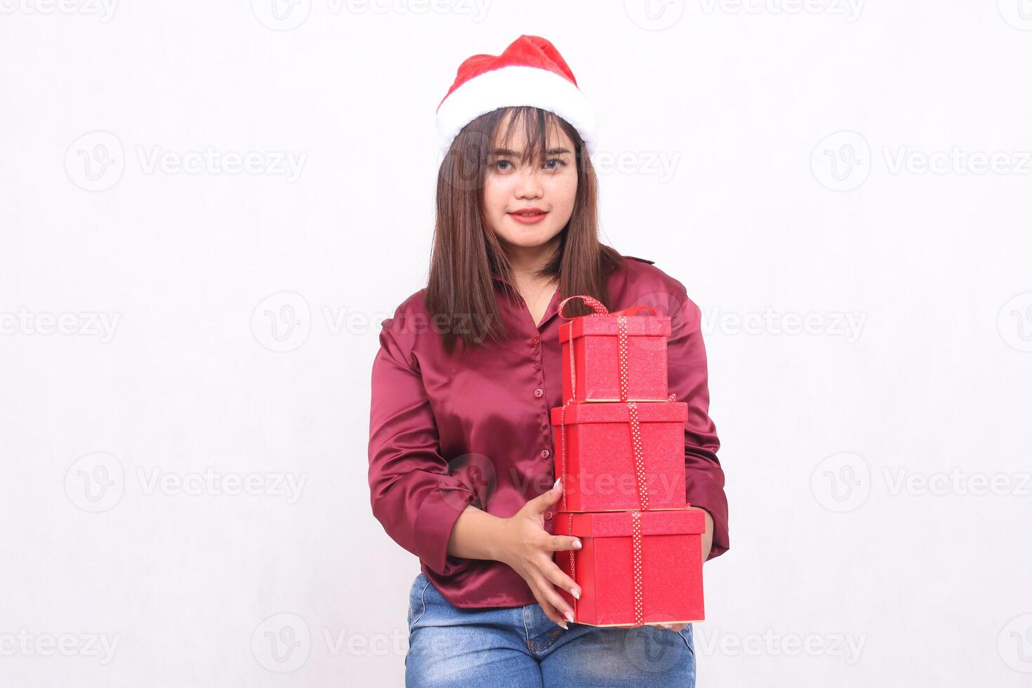 vrolijk jong mooi zuidoosten Aziatisch meisje draag- 3 dozen van cadeaus Bij Kerstmis vervelend de kerstman claus hoed modern rood overhemd kleding Holding allemaal wit achtergrond voor Promotie en reclame foto