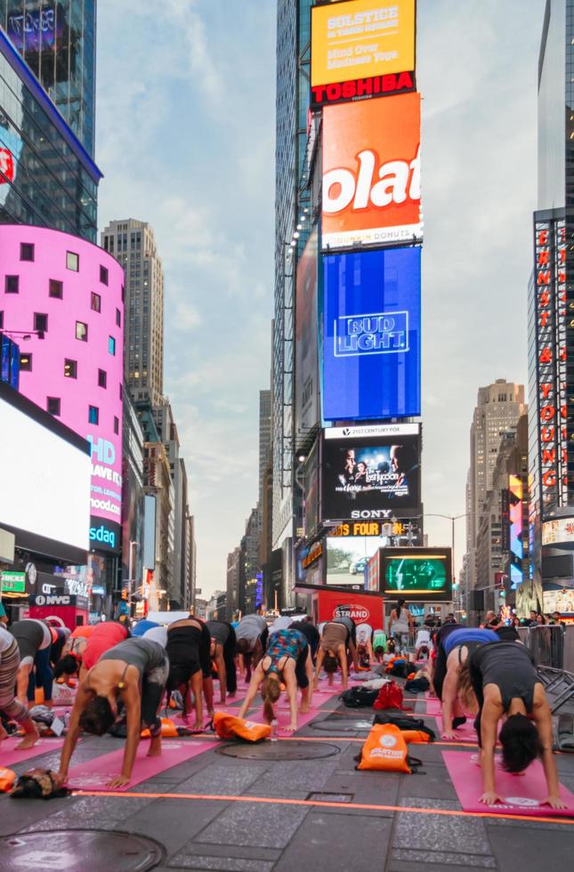 New York City, Verenigde Staten - 21 juni 2016. mensen die zich uitstrekken in de jaarlijkse yoga-concentratie op de zomerzonnewende in Times Square, iconisch symbool van New York City en de Verenigde Staten van Amerika foto