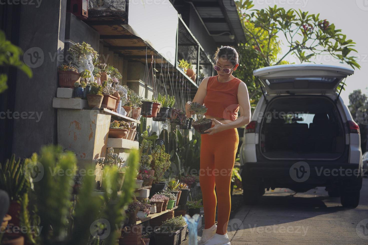 mooie vrouw met een sappige pot in de hand die in de tuin staat foto