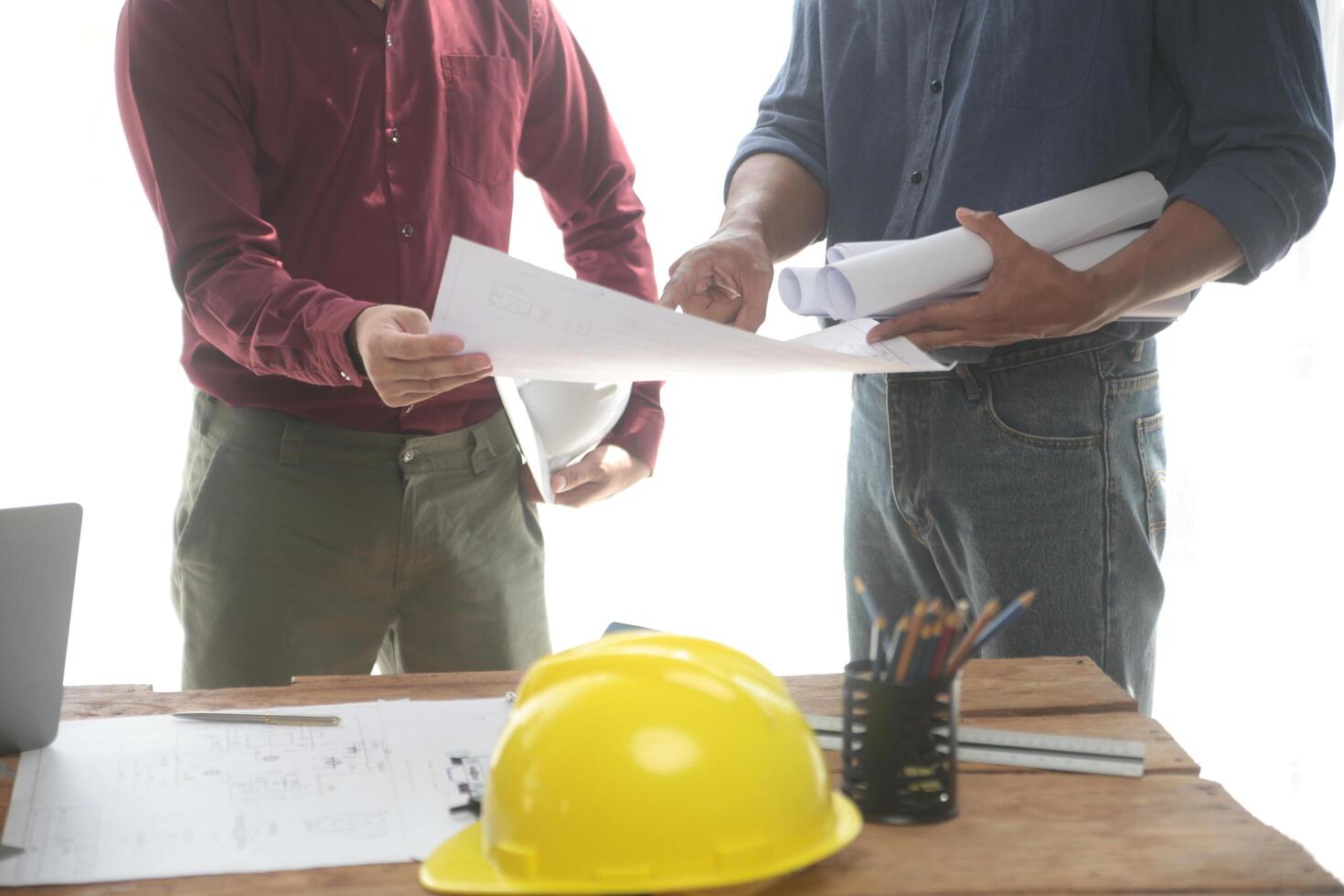 verschillend team van specialisten gebruik laptop Aan bouw plaats. echt landgoed gebouw project met ingenieur investeerder en zakenman controle Oppervlakte, werken Aan civiel engineering, bespreken strategie plan foto