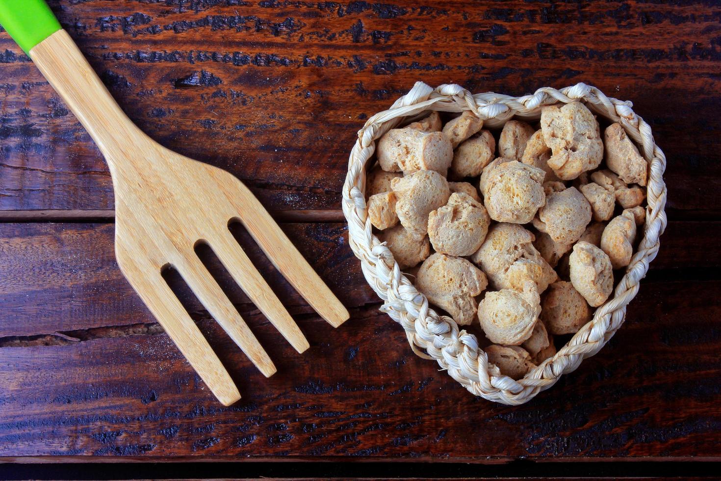 sojabonenvlees, brokken in een mand met hartvorm. rauwe sojabonenbrokken op rustieke houten achtergrond foto