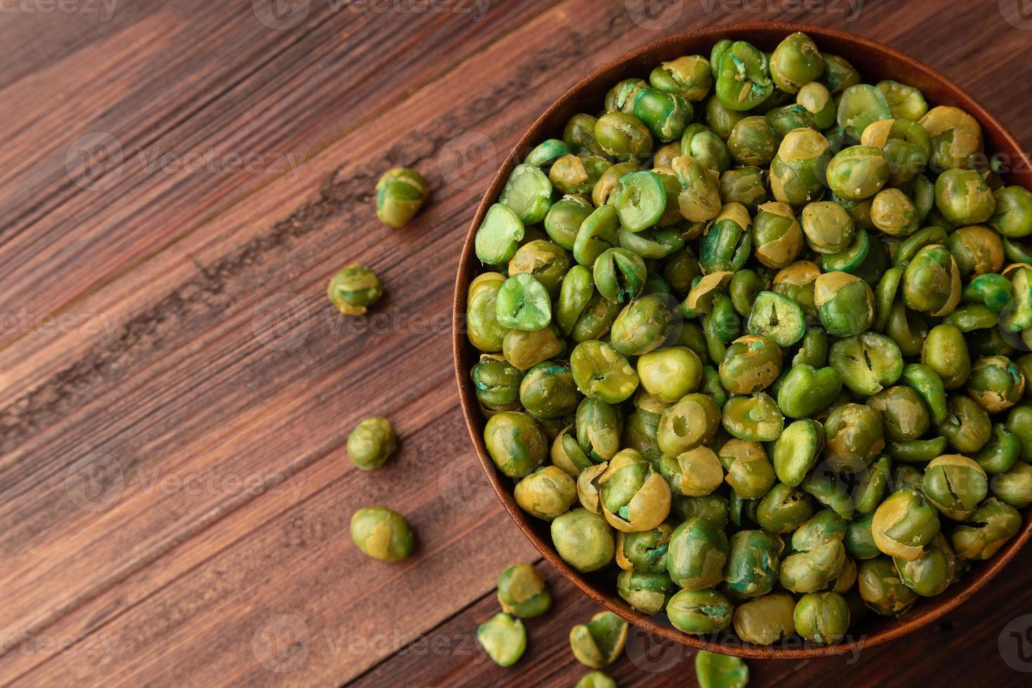 gezouten groene erwten in houten kom op tafel, gezonde snack, vegetarisch eten foto