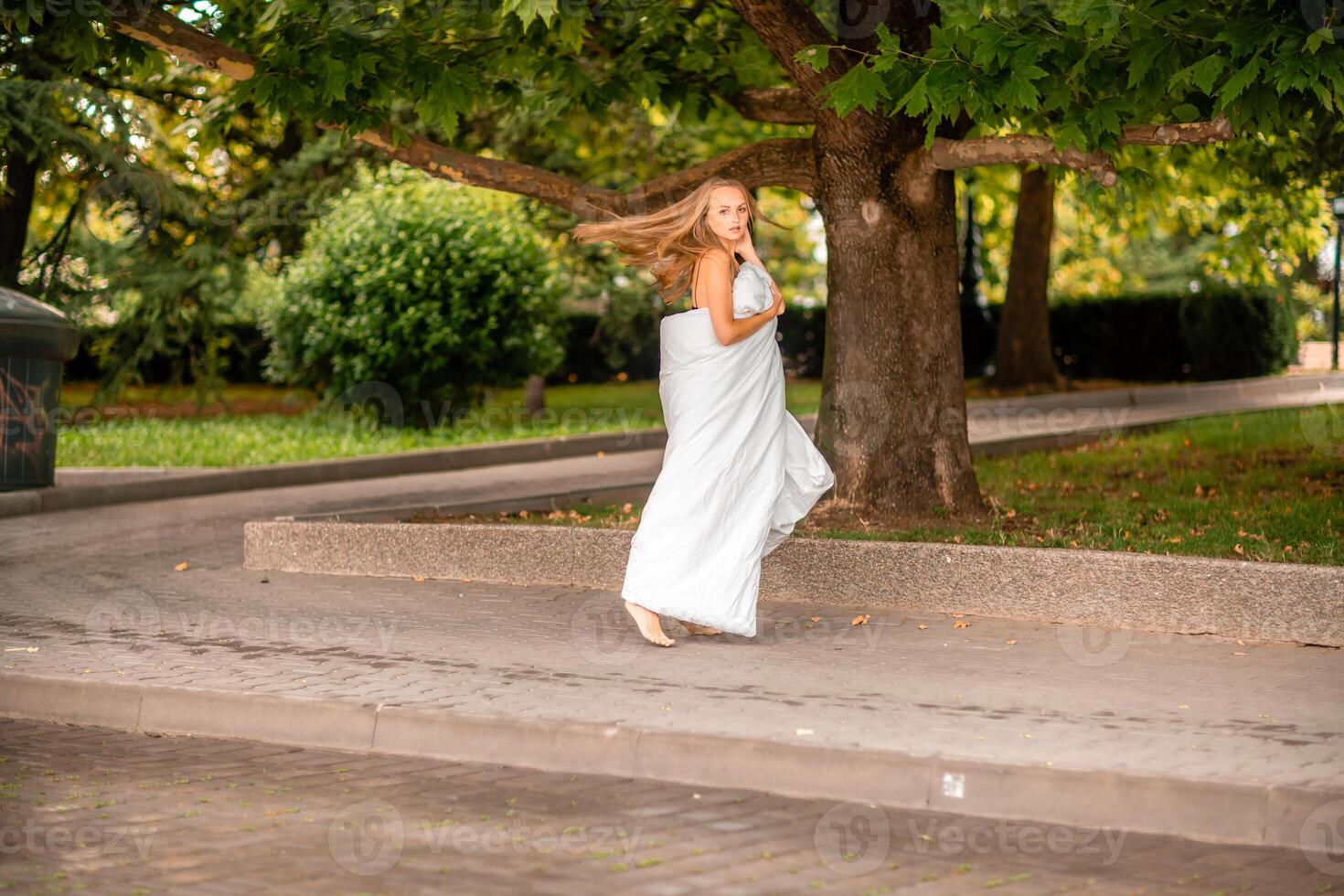 vrouw stad deken. ochtend- in de groot stad. een blond vrouw in een wit deken is genieten van in de stad centrum. gefotografeerd voor sociaal media foto