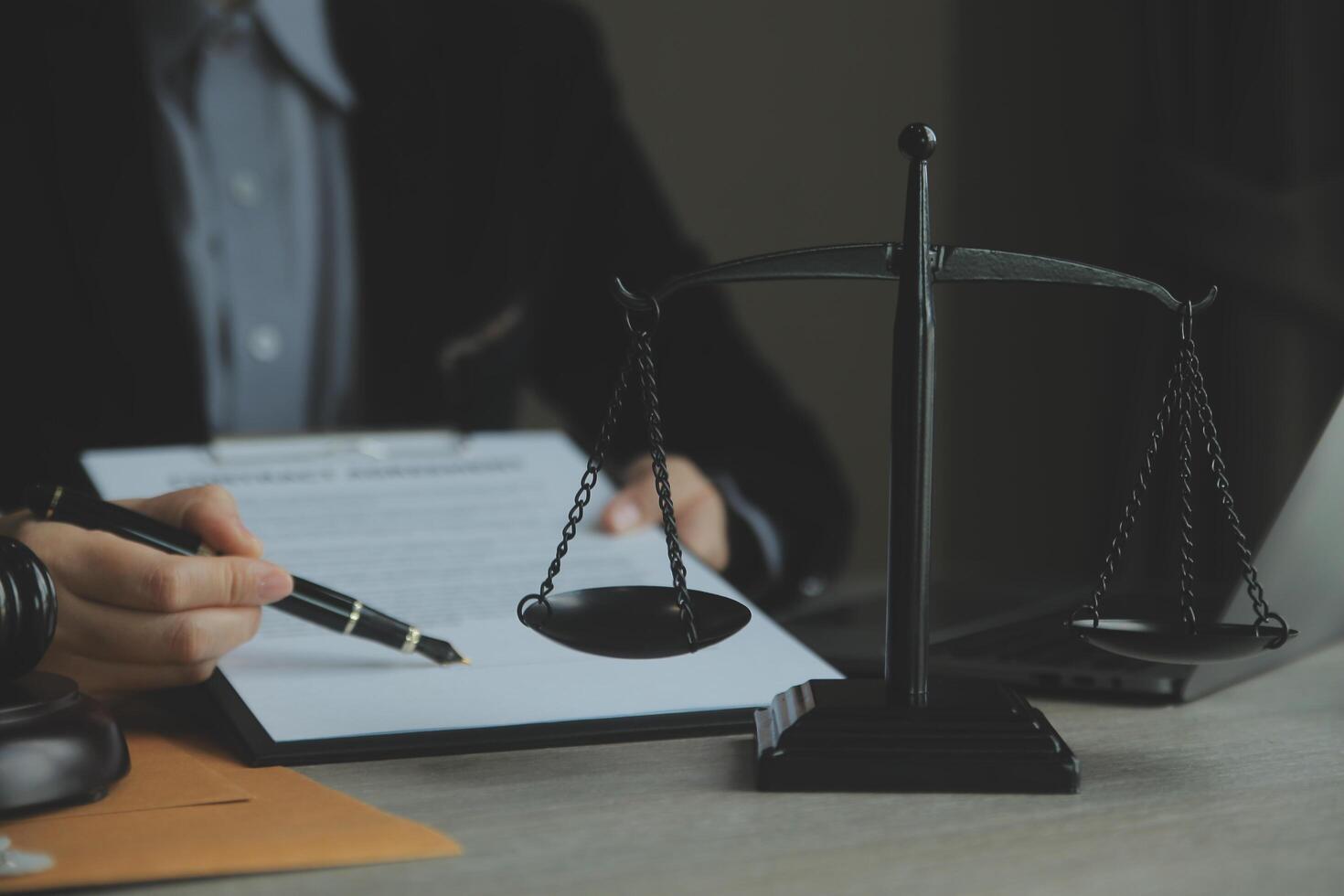 zaken en advocaten bespreken contractpapieren met koperen schaal op bureau in kantoor. wet, juridische diensten, advies, rechtvaardigheid en wet concept foto met film grain effect