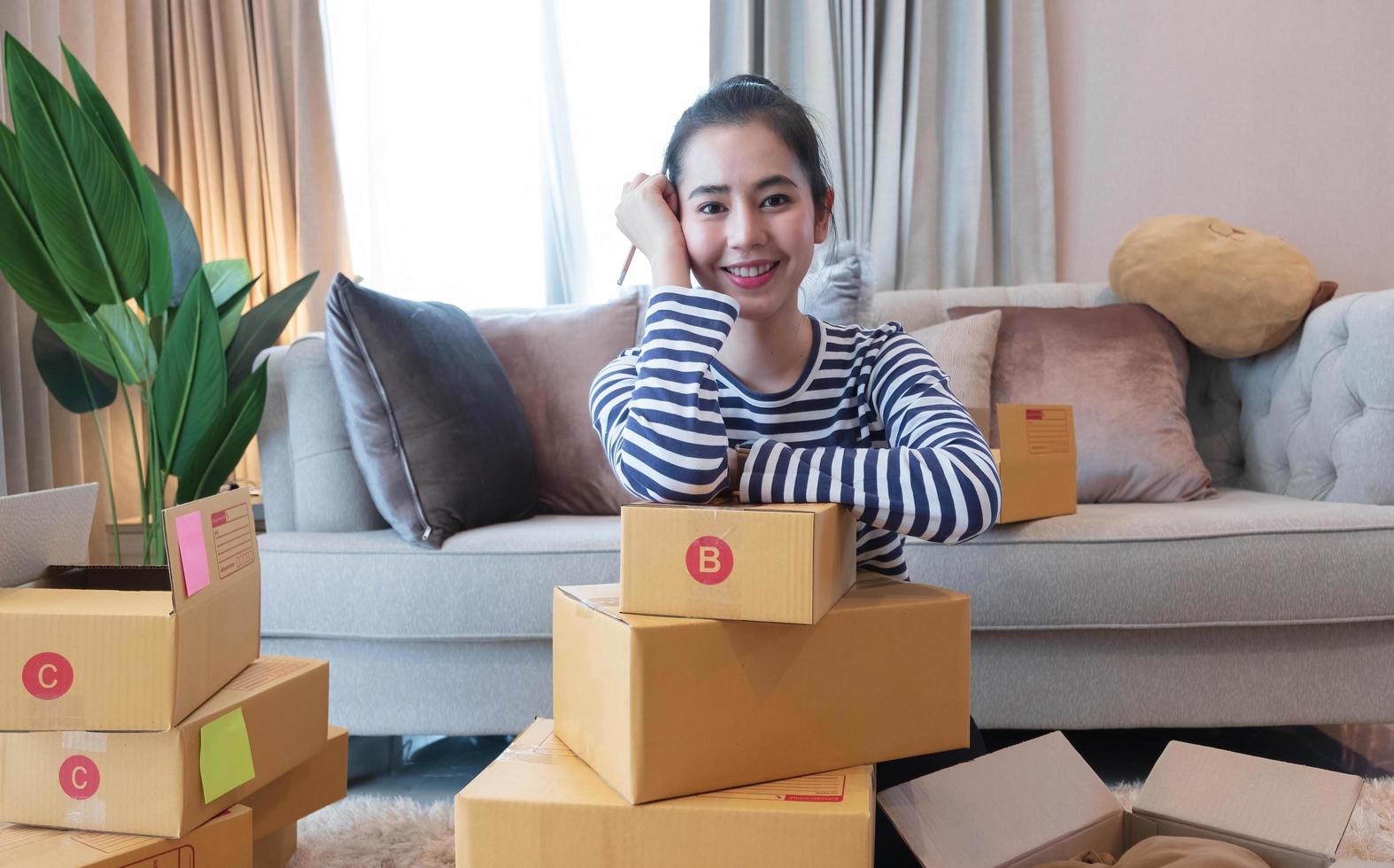 kleine ondernemer mkb-ondernemer van jonge aziatische vrouwen die met laptop werken om thuis online te winkelen, vrolijk en blij met doos voor verpakking in huis, eigen bedrijf opstarten voor online zaken foto