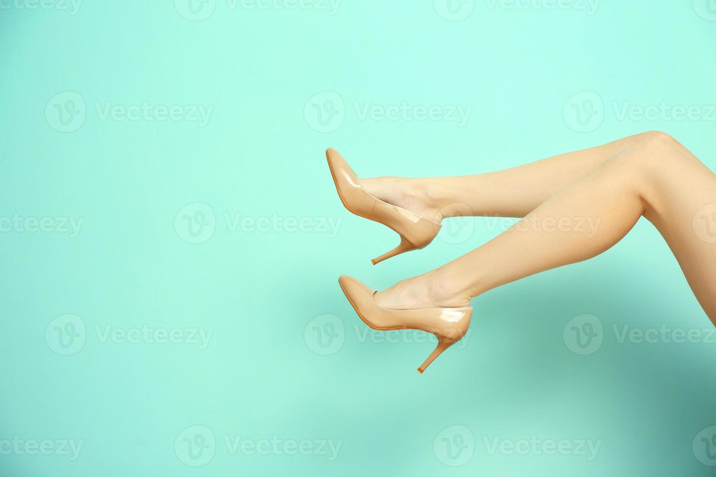 benen van jonge vrouw in elegante schoenen op gekleurde achtergrond foto