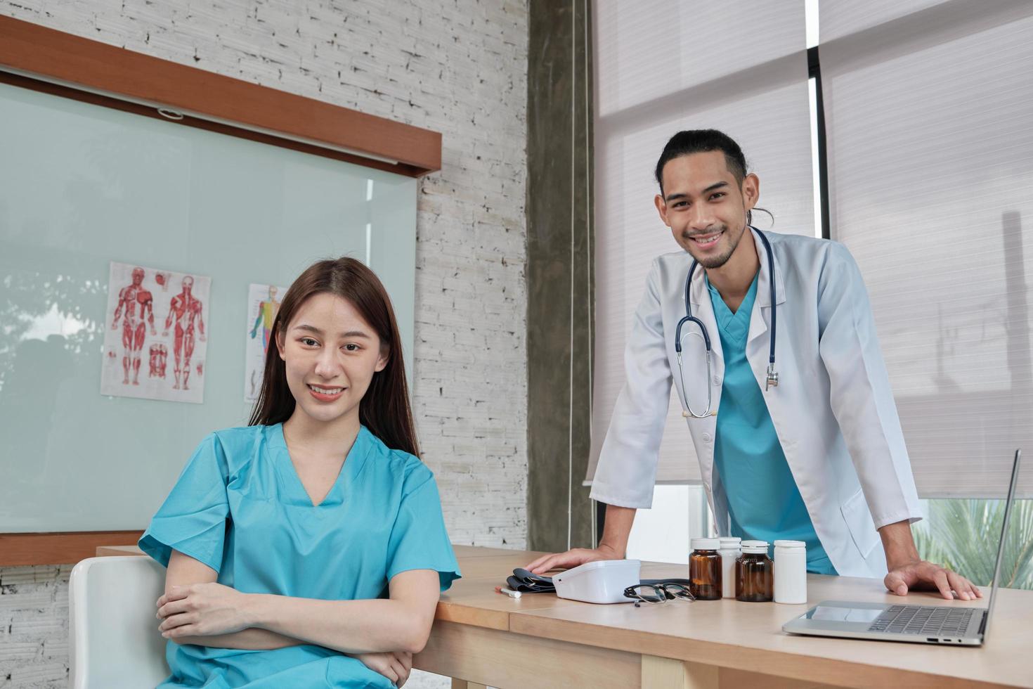 team van gezondheidspartners, portret van twee jonge artsen van Aziatische etniciteit in uniform met stethoscoop, glimlachend en kijkend naar camera in kliniek, personen met expertise in professionele behandeling. foto