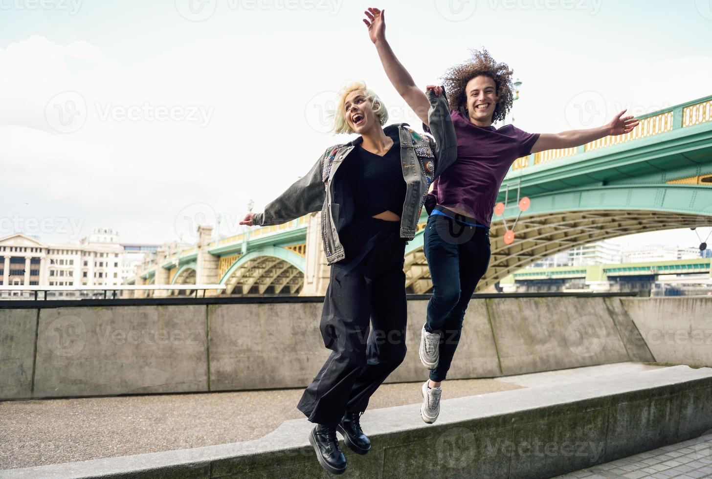 grappig paar dat dichtbij de Southwark-brug over de rivier de Theems springt, Londen foto