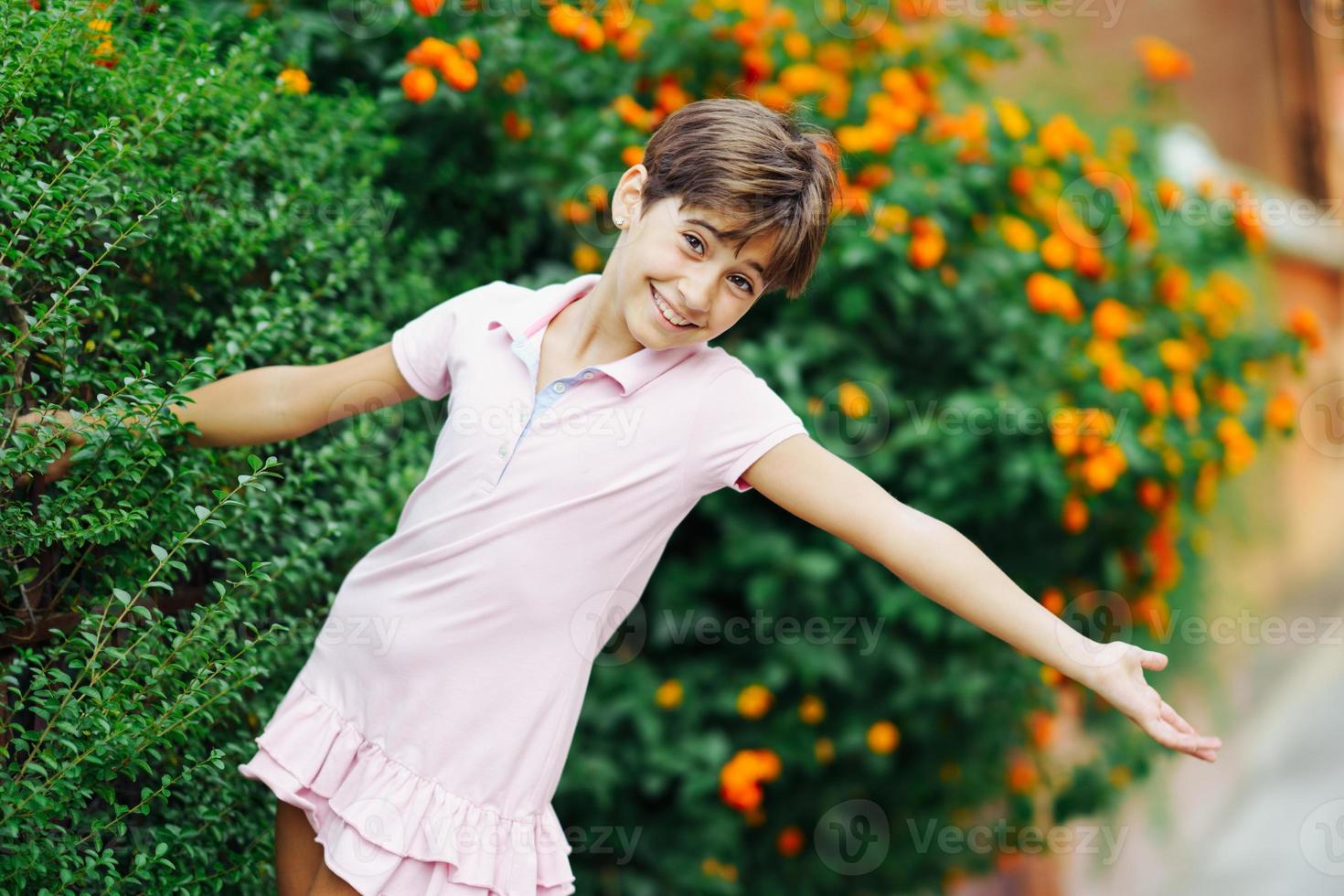 klein meisje, acht jaar oud, met plezier in een stadspark. foto