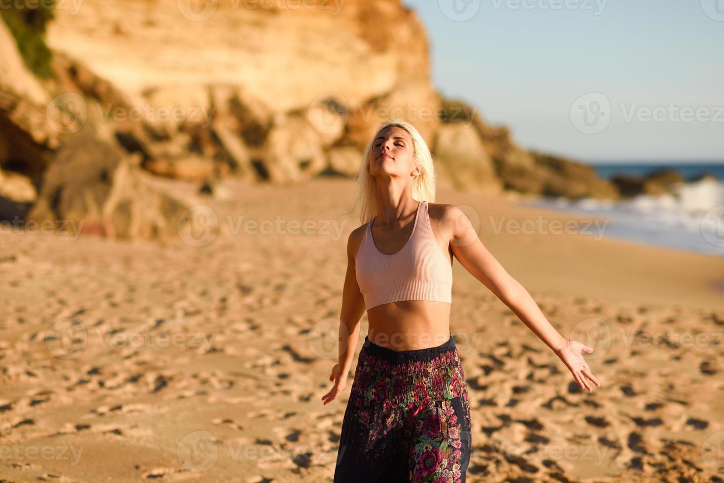 vrouw geniet van de zonsondergang op een prachtig strand foto