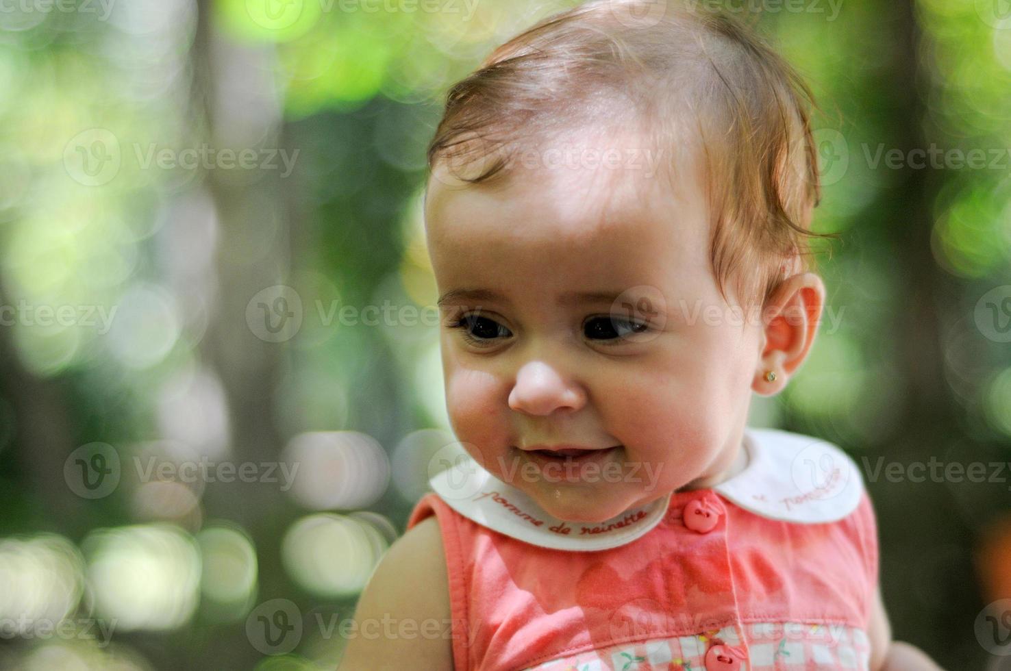 zes maanden oude babymeisje glimlachend buitenshuis. foto