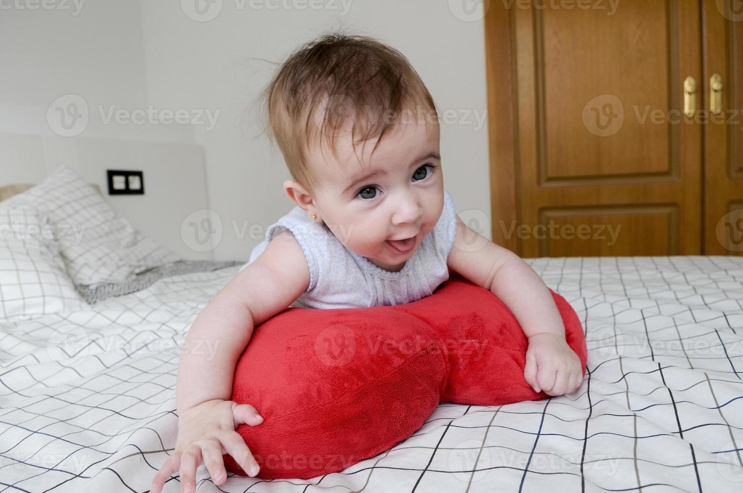 babymeisje, vier maanden oud, op het bed foto