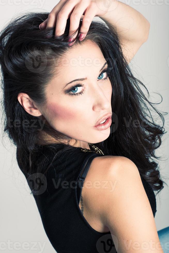 brunette vrouw met blauwe ogen, gekleed in shirt en spijkerbroek foto