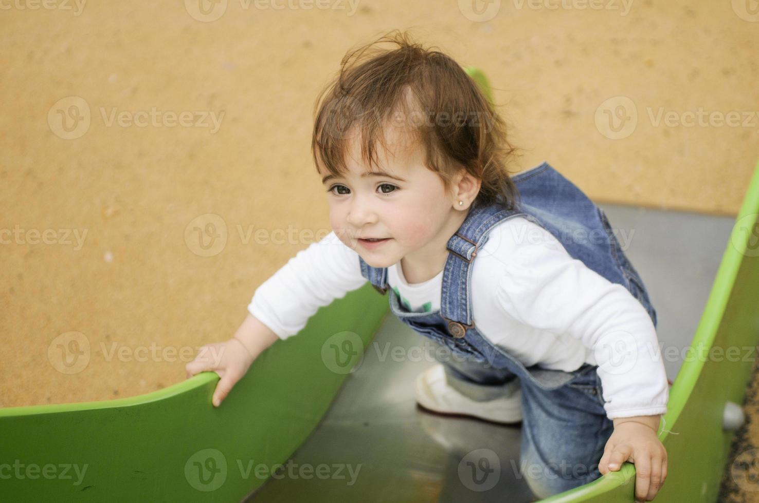 klein meisje spelen in een stedelijke speeltuin. foto