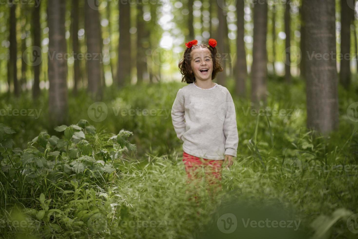 schattig klein meisje dat plezier heeft in een populierenbos foto