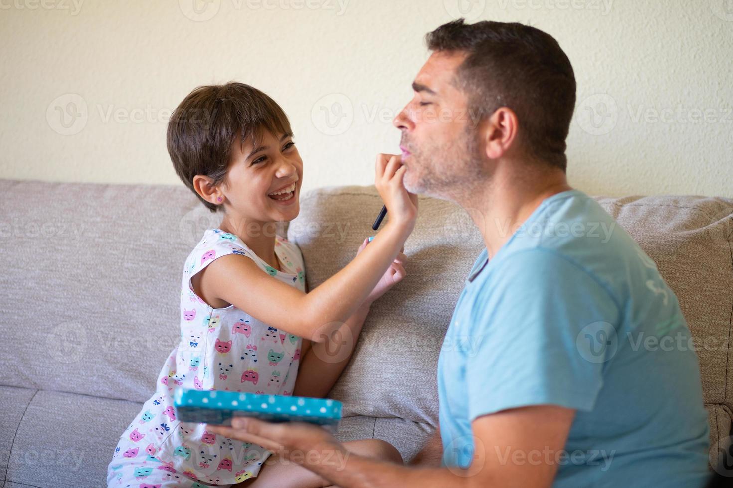 kleine schattige dochter die make-up doet voor haar vader foto