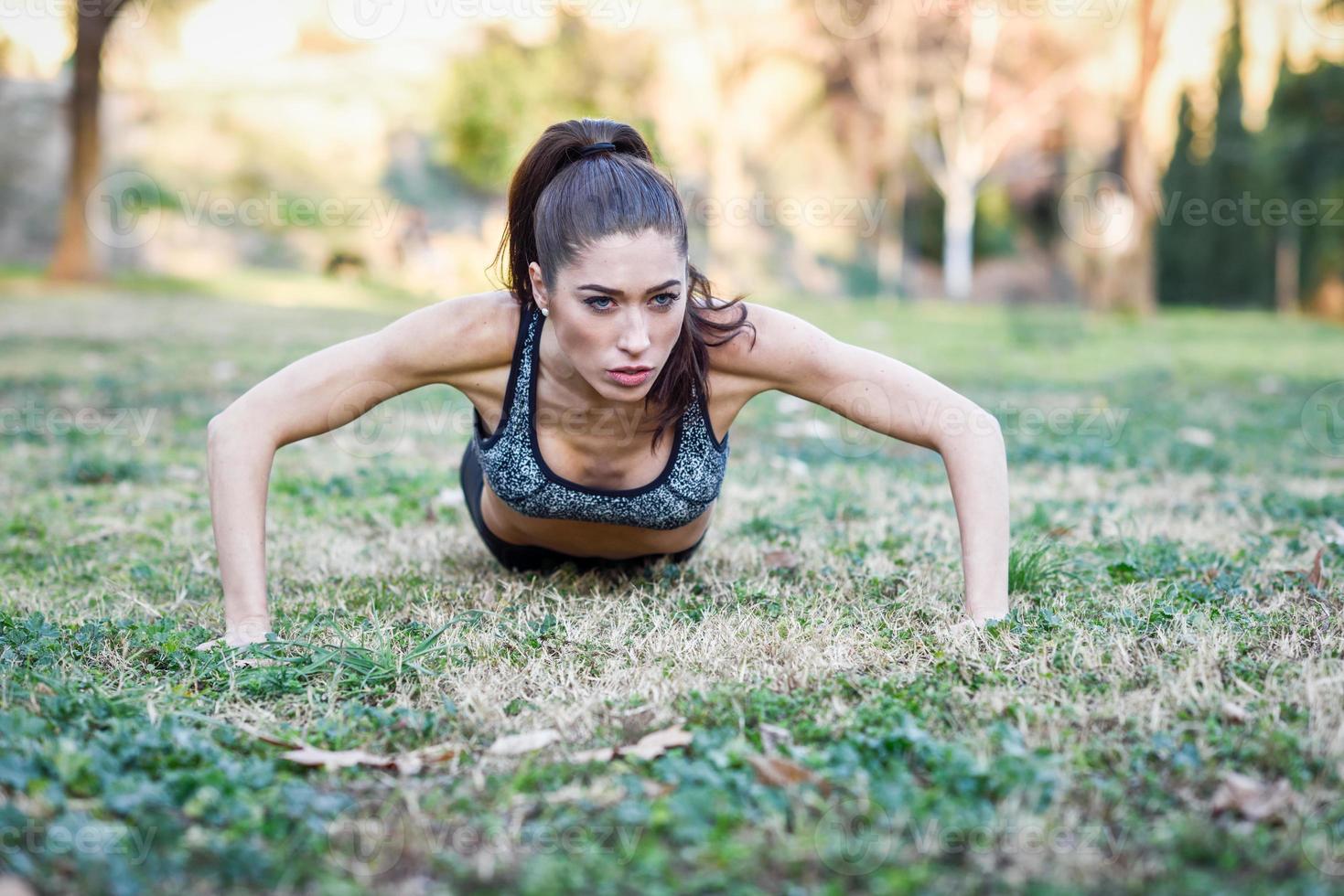 fitness meisje doet push-ups buitenshuis foto