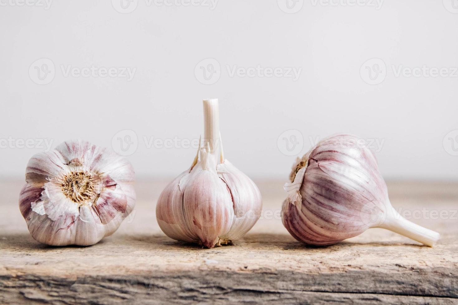 knoflook ligt op een rij op een rustieke houten achtergrond foto