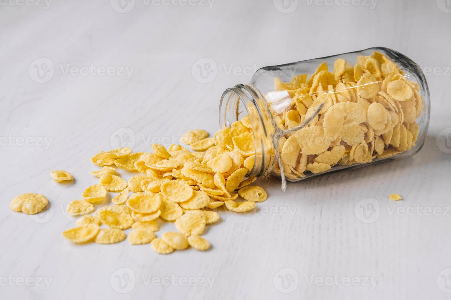 cornflakes in een glazen pot op witte houten tafel foto