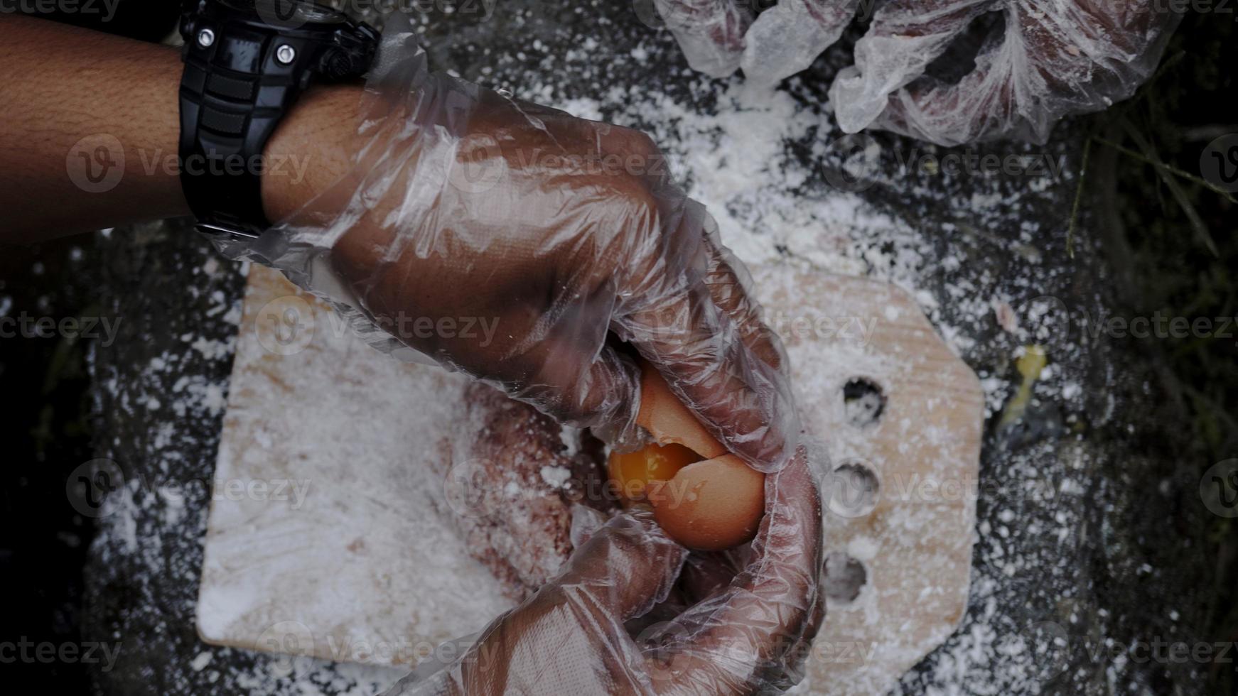 een jonge chef-kok maakt hamburger-vuldeeg aan de rand van een waterval foto