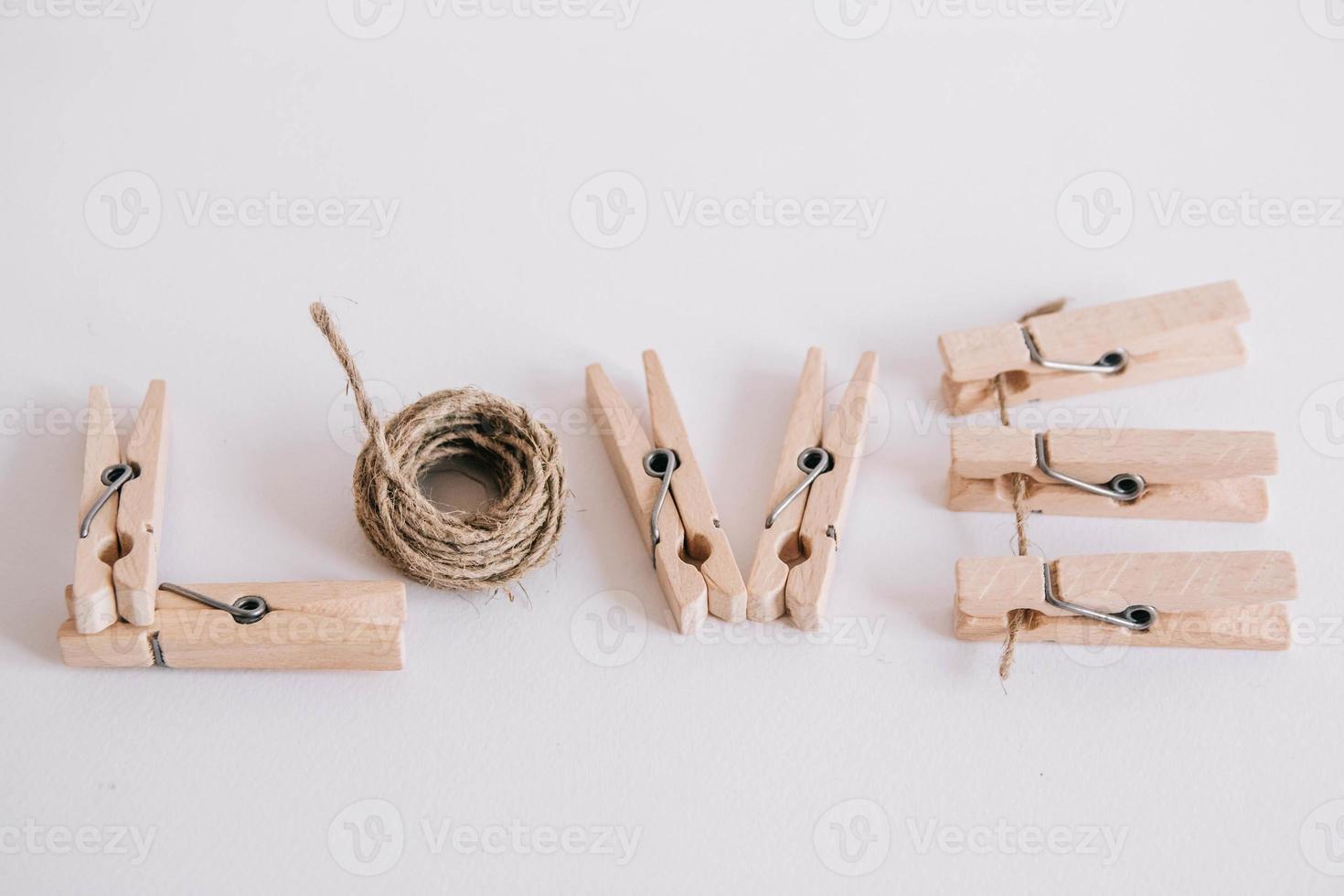 houten wasknijpers met touw op witte achtergrond met het opschrift het woord love foto