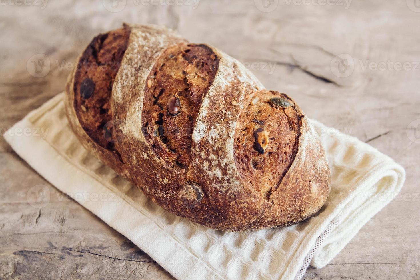 bruin vers brood met zaden op oude houten ondergrond foto