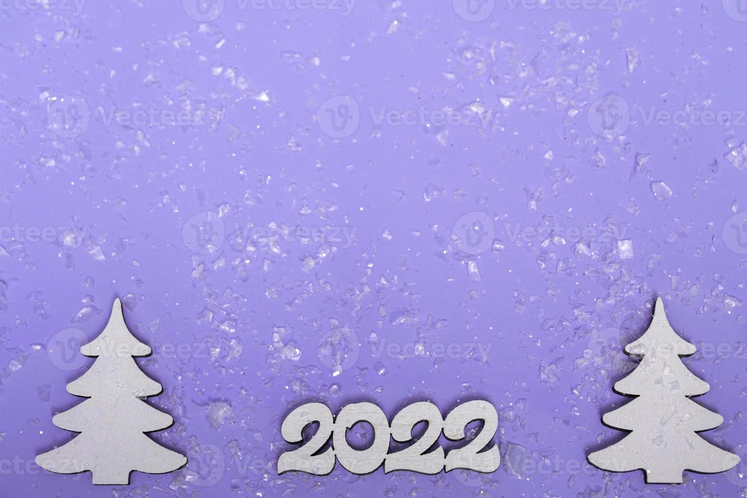 vrolijk kerstfeest en een gelukkig nieuwjaar. feestelijke poster met een kerstboom, sleeën op een paarse achtergrond met verlichting. nieuwjaar 2022 kopieerruimte close-up foto