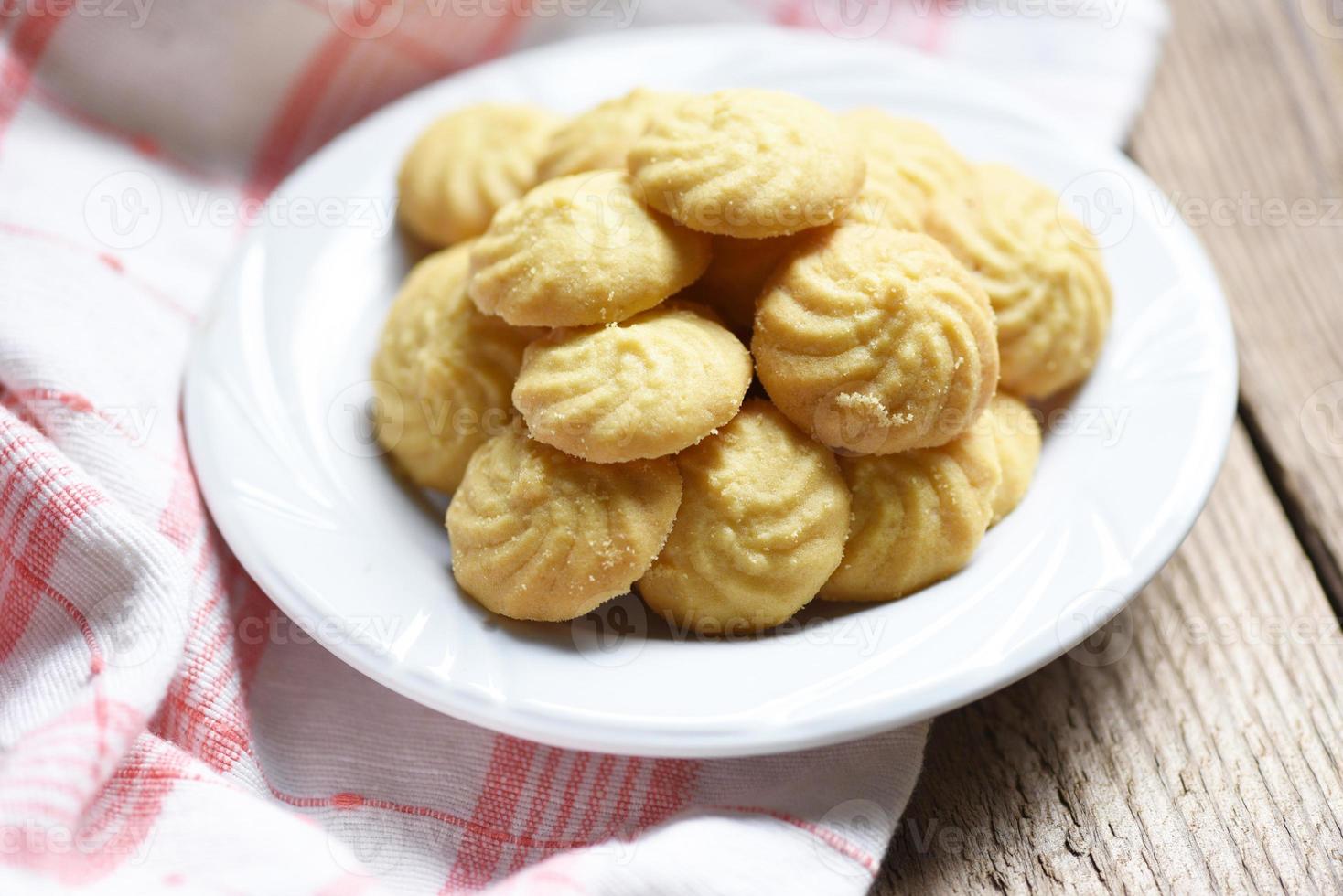 koekjes vanille op witte plaat en houten achtergrond, mini cookies koekjes foto