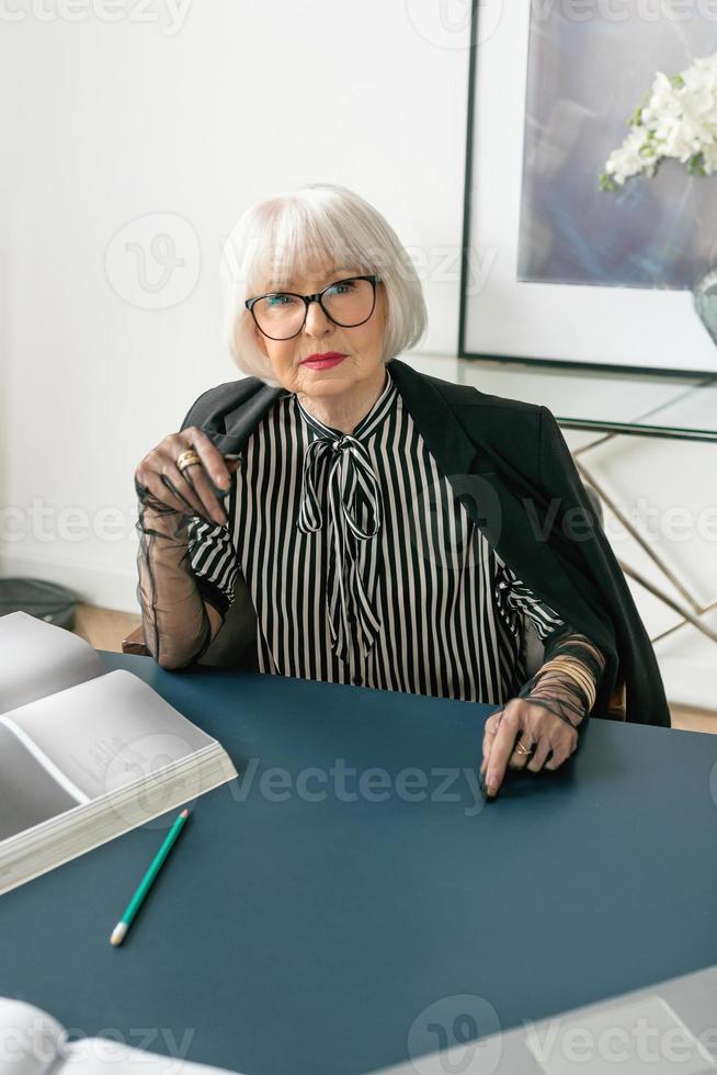 senior mooie grijze haren vrouw in haar kantoor. werk, senioren, problemen, zaken, ervaringsconcept foto