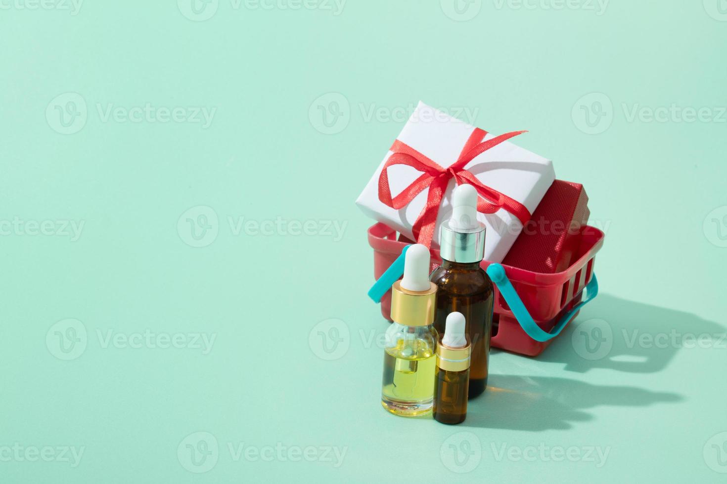 cosmetische olie- en serumflessen met pipet en kerstcadeaus in winkelmandje foto