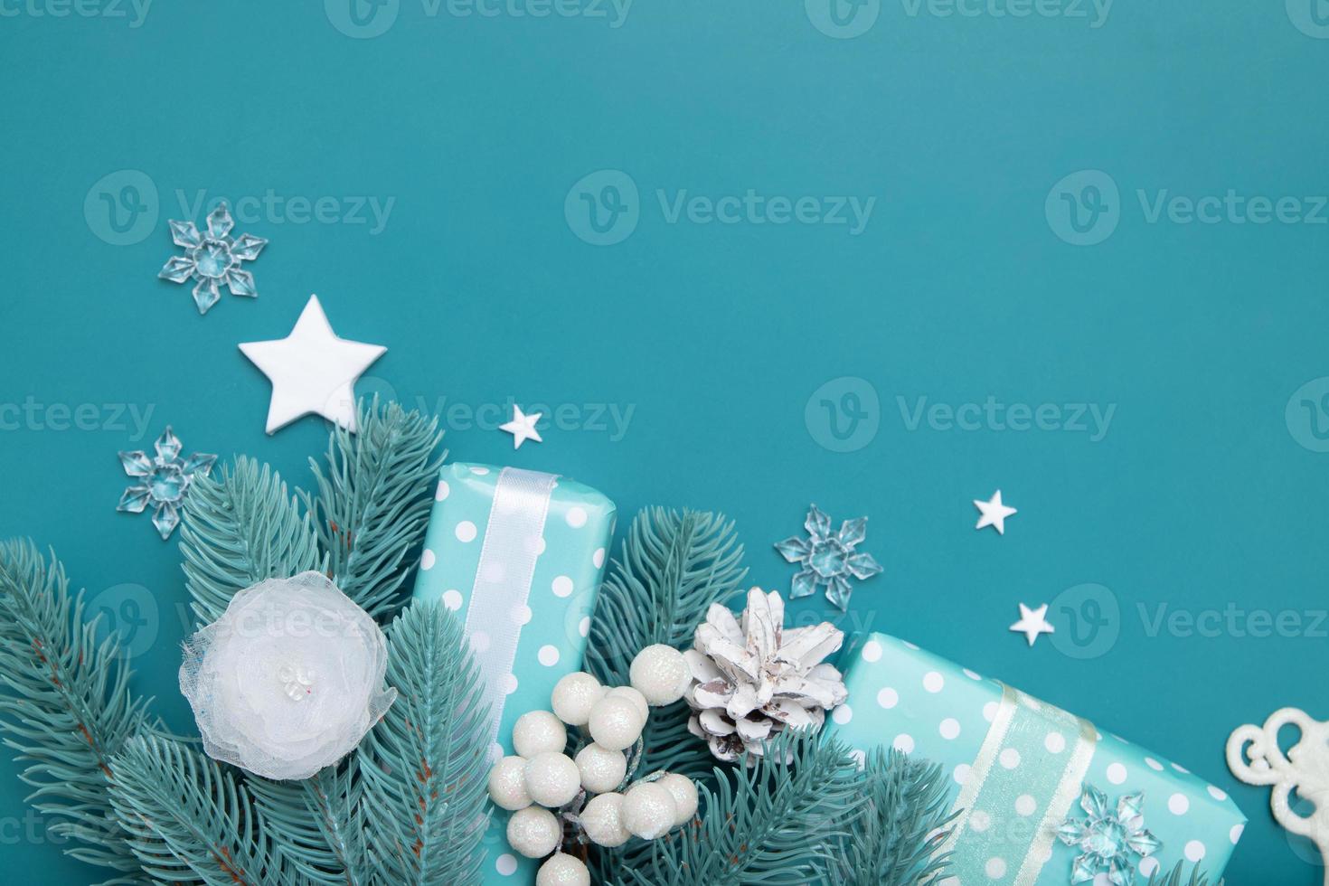 Kerstachtergrond met geschenken, sterren, bessen en dennen plat op een turquoise achtergrond met kopieerruimte foto