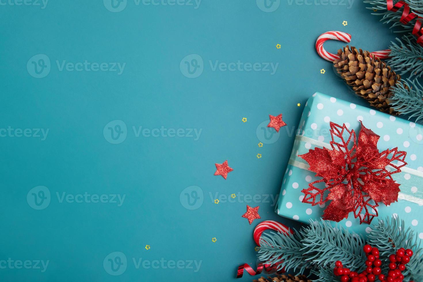kerst plat lag achtergrond met geschenken, rode bessen en dennenboom op turquoise achtergrond foto