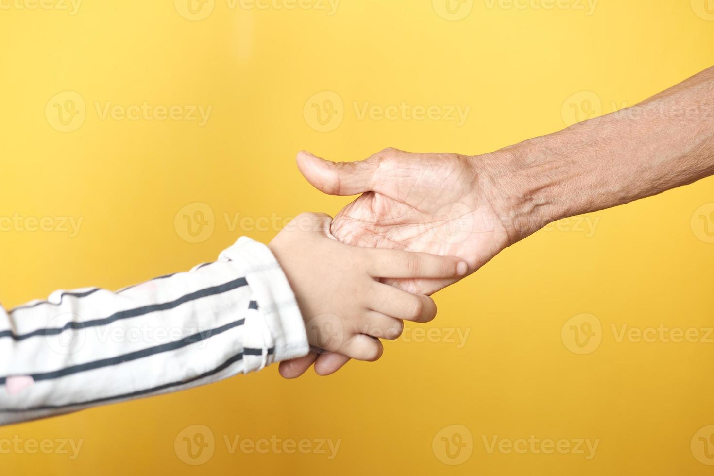 kind meisje hand in hand van een senior vrouw foto