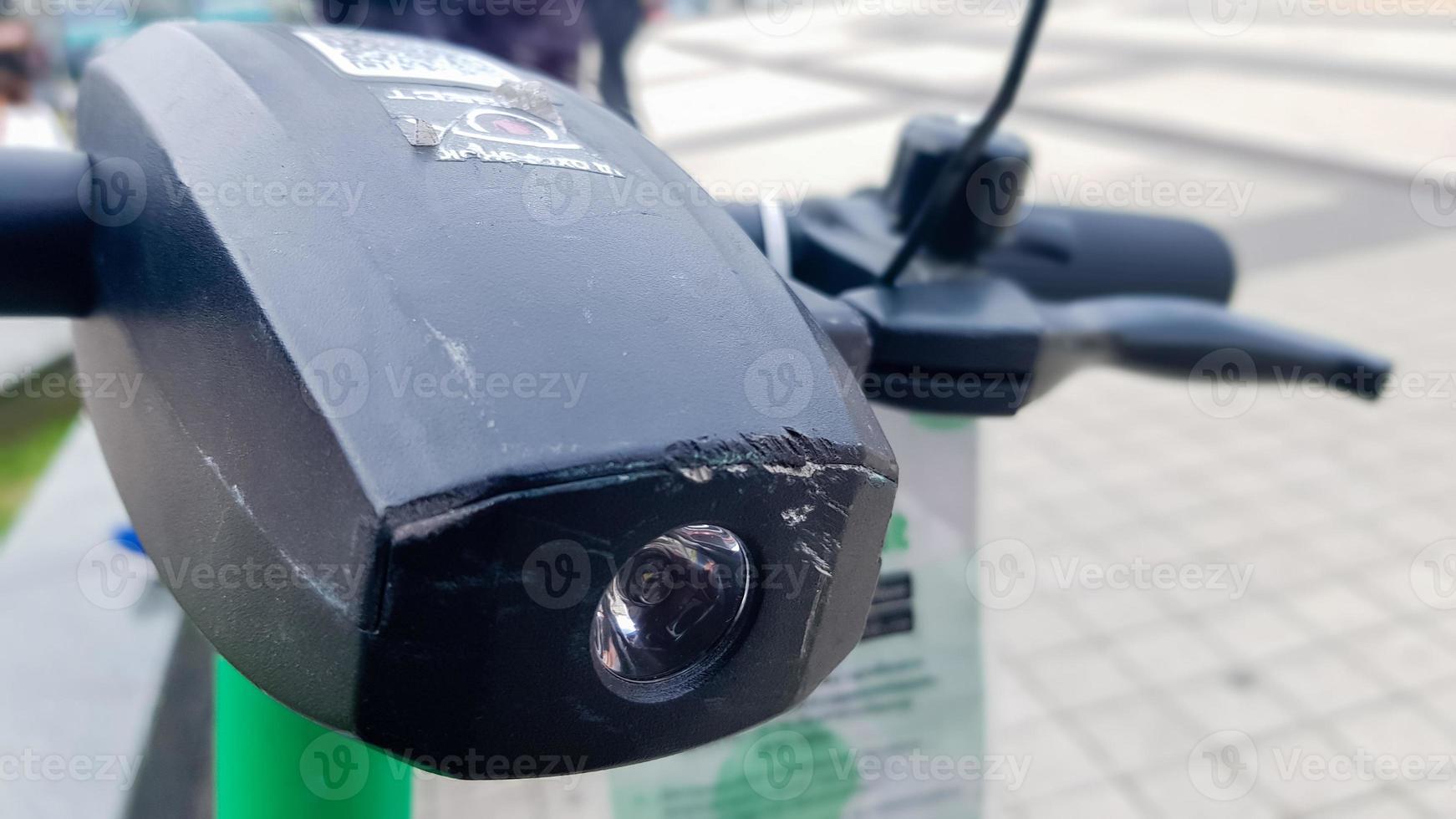 close-up van het stuur van een elektrische scooter met een zaklamp. verhuur van elektrische scooters in de stad buiten. veiligheidsprobleem bij het rijden. ecologisch vervoersconcept. foto