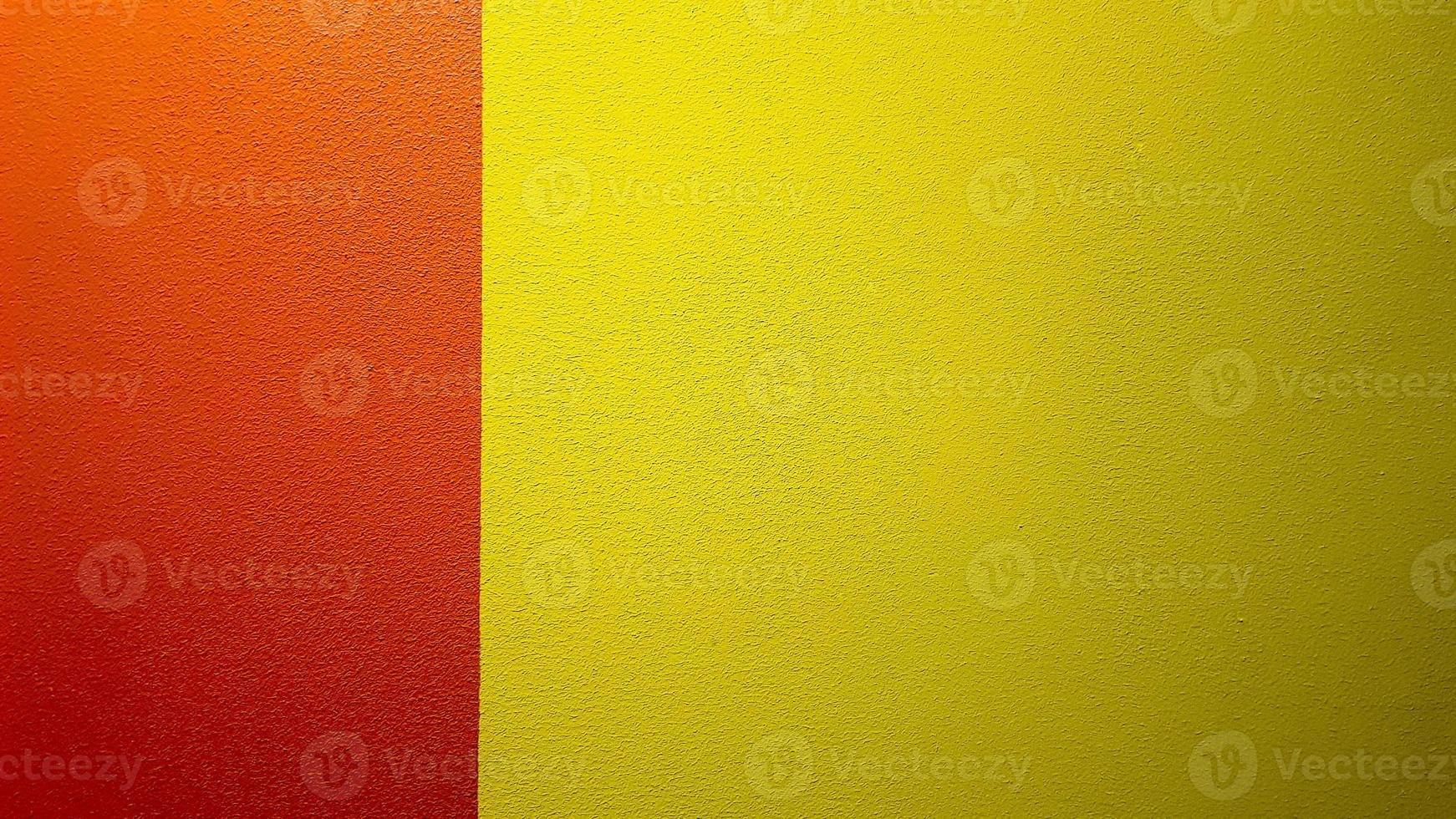 rood en geel geschilderde muur textuur abstracte grunge achtergrond met kopie ruimte. abstract geometrisch patroon op de muur. de muur is verdeeld in randen van verschillende kleuren foto