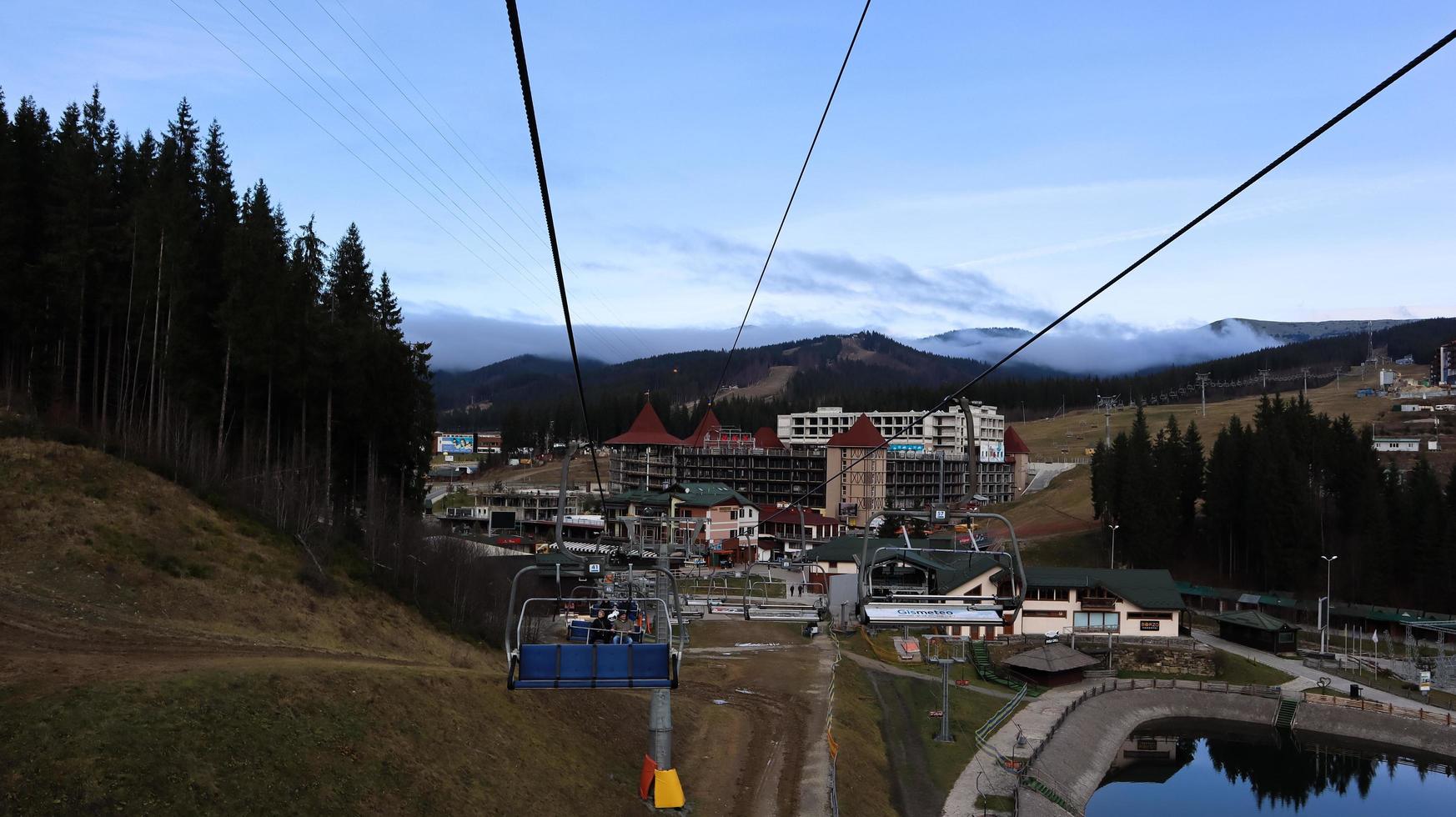 Oekraïne, Boekovel - 20 november 2019. Herfstzicht op het skigebied met een stoeltjeslift tegen de achtergrond van herfstberghellingen en de infrastructuur in aanbouw van een winterskiresort. foto